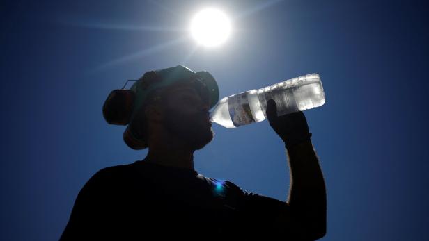 Frau trinkt aus Wasserflasche bei Hitze