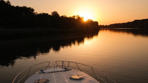 Hausboot auf der Theiß in Ungarn bei Sonnenuntergang, Blick aufs Wasser