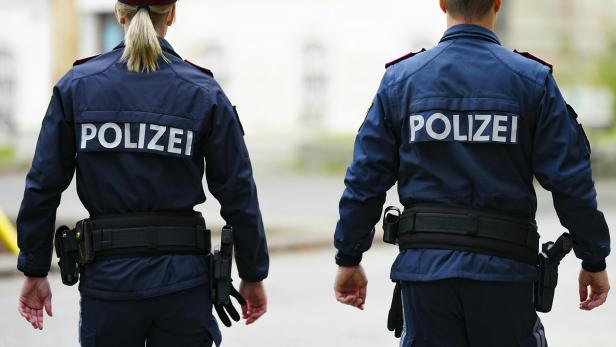 Polizistin und Polizist mit Aufschrift "Polizei" am Rücken