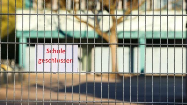 Schild mit Schulen geschlossen hinter einem Gitter.