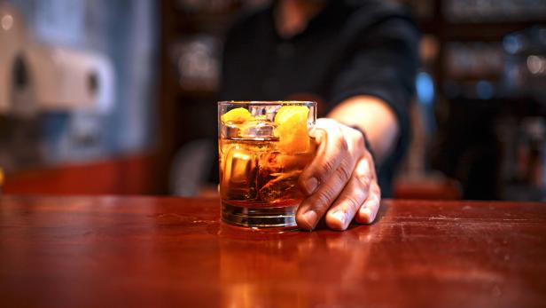 Bartender serving a cocktail drink on a bar counter